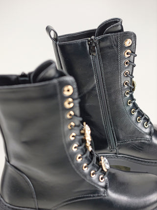 OFF#DLY Boot Salerno black, ein Paar schwarze Lederstiefel mit robustem Design, ideal für Arbeit oder Freizeit. Markante Details umfassen eine goldene Verzierung. Perfekte Wahl für stilvolle Funktionalität.