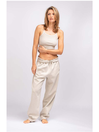 True Religion Volume Pant palbeige: Frau in weißem Tanktop trägt locker geschnittene, hochbundige Joggpant im Washed-out-Look mit Tunnelzug, aus 100% Baumwolle.