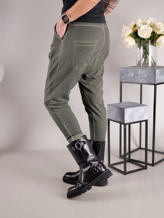 OFF#DLY Jogger Pant Tina khaki: Person trägt lässige Baggy-Jogger mit Gummibund und Kordelzug, seitliche Taschen sichtbar, kombiniert mit schwarzen Stiefeln.