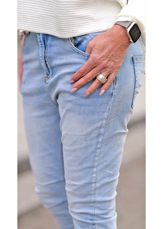 Nahaufnahme der OFF#DLY Light Denim Sina hellblau, zeigt eine Hand mit einem Ring in der Gesäßtasche einer Jeans. Die Hose hat einen schmalen, leicht baggy Schnitt.