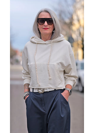 OFF#DLY Hoody Selma beige: Frau mit grauem Haar trägt lässigen Kapuzenpullover, große Sonnenbrille; bequemer, boxy Schnitt. Geeignet bis Größe 40. Ideal für Street Fashion.