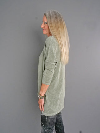 Frau trägt ESV Shirt 3611 in khaki, lässig geschnitten mit 3/4-Ärmeln und Rundhalsausschnitt. Der Oversized-Look ist vorne kürzer, ideal für vielseitige Stylings.