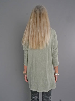 Eine Frau trägt das ESV Shirt 3611 in khaki, mit lässigem Oversized-Look und 3/4-Ärmeln. Das Shirt hat einen Rundhalsausschnitt und wirkt vorne kürzer als hinten.